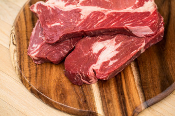 Fresh beef steaks on wooden board