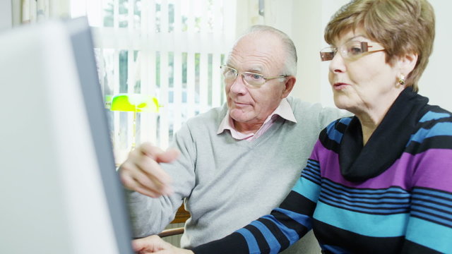 An elderly couple are browsing the internet together