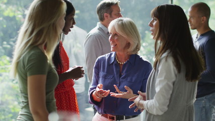 Female friends or casual business colleagues chatting together at a social event - Powered by Adobe