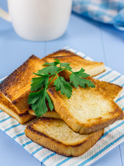 Toasts on breakfast, decorated with parsley, and a cup of coffee