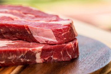 Fresh beef steaks on wooden board