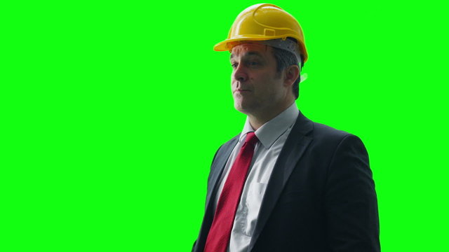 Portrait of businessman wearing a hard hat on green screen background