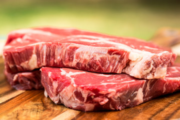 Fresh beef steaks on wooden board