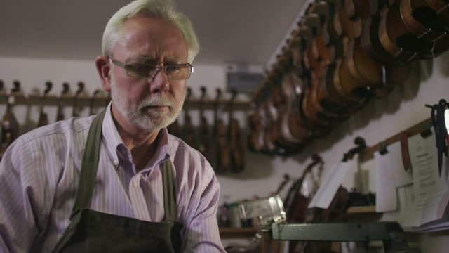 Father and son shopping together, looking at violins in a musical store