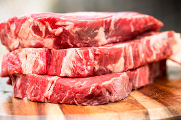 Fresh beef steaks on wooden board