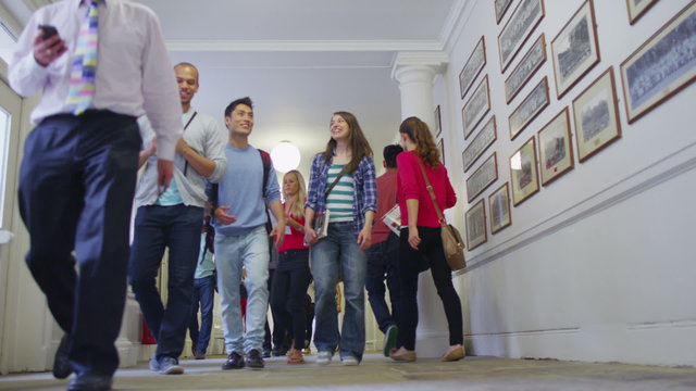 Mixed ethnicity group of students chatting in the hallway between classes