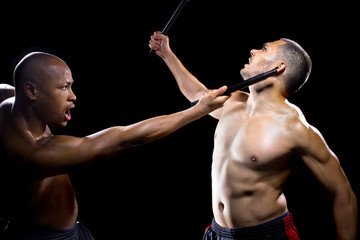 two men sparring with Filipino stick fighting martial arts