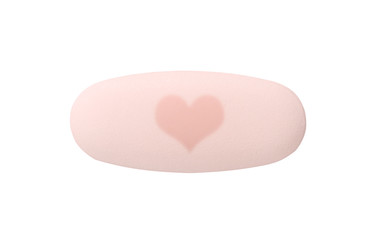 Macro red medical pill tablet with heart isolated on white