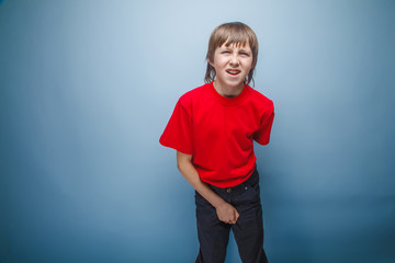 teenager boy in red T-shirt European appearance brown hair holds - obrazy, fototapety, plakaty