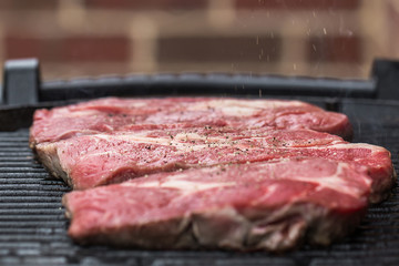 Fresh beef steaks on grill or BBQ