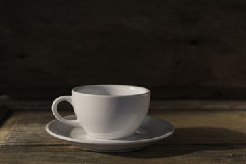 Cup of coffee on grunge wood table in vintage style