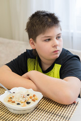 Teenager boy refuses to eat oatmeal for breakfast