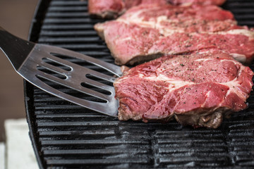 Beef steaks on grill or BBQ with spatula