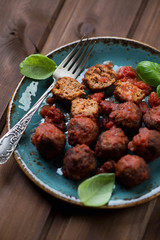 Plate with meatballs over dark wooden background, close-up
