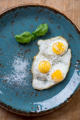 Close-up of fried quail eggs on a turquoise plate, above view