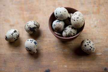 Obraz premium Raw quail eggs over rustic wooden surface, studio shot