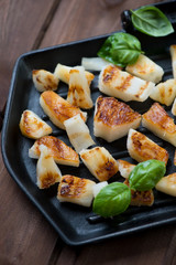 Grill with barbecued pineapple slices and green basil, close-up