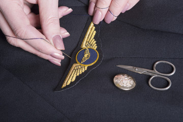 Fototapeta premium Sewing wings onto a uniform jacket