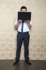 businessman is hiding behind a laptop