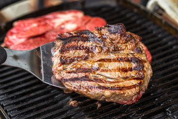 Beef steaks on grill or BBQ with spatula