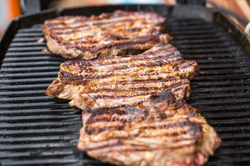 Beef steaks on grill or BBQ with spatula