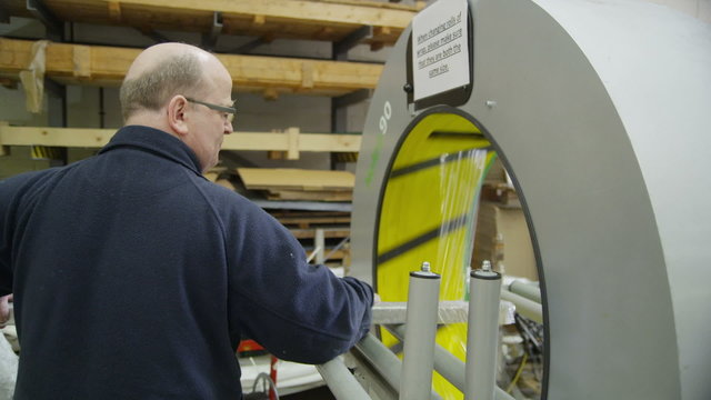 Operator using a packaging machine to prepare goods for delivery