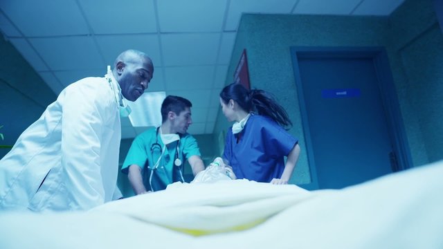 Hospital emergency team rush a patient on a gurney to the operating theatre