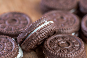 Chocolate cookies with creme on wooden table