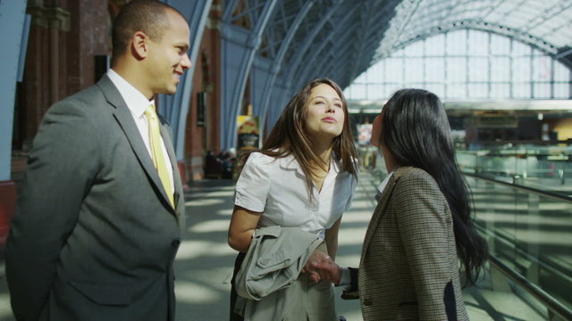 Business group meet and shake hands at London's St. Pancras railway station.