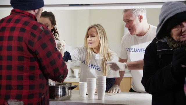 Soup kitchen volunteers help to feed the homeless