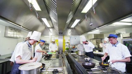 Team of professional chefs preparing and cooking food in a commercial kitchen - Powered by Adobe