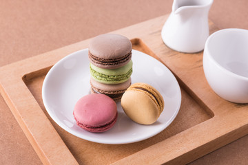Frence sweet delicacy macaroons and white coffee cup on wood bac