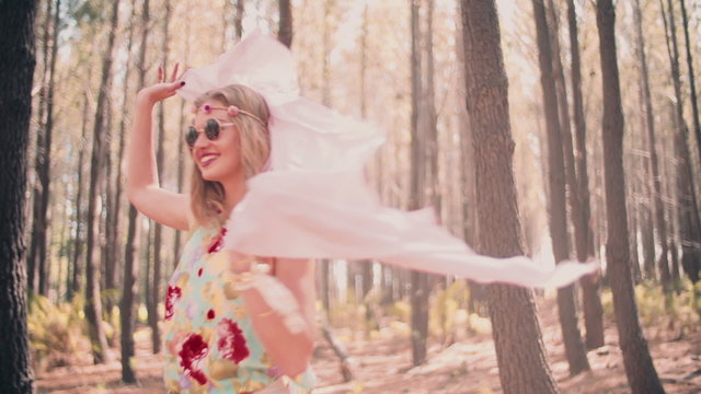 Fashion shot of a boho girl running in a forest