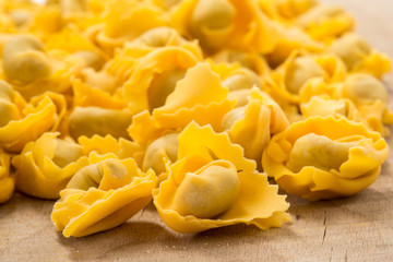 Ravioli freschi crudi su un asse di legno 