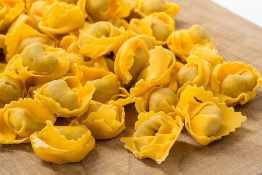 Ravioli freschi crudi su un asse di legno 