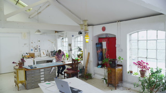 Casual young man working from home in his modern loft style apartment
