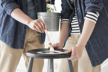 Young couple are painting on a chair