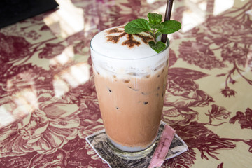 Ice coffee with whipped cream and coffee beans on a table