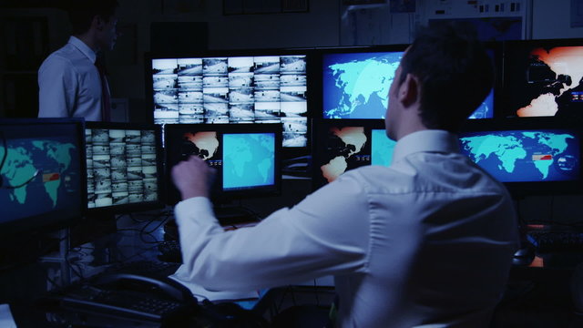Security personnel working in system control room.