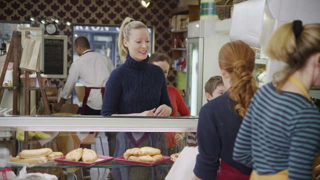 Happy customers being served by friendly staff at the bakery counter