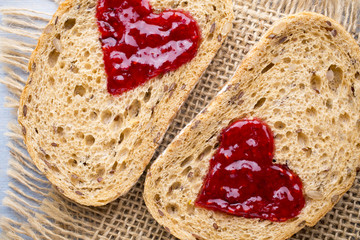 Grain slice of bread with jam heart shape.