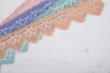 colorful lace ribbons as a border on wooden background