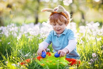 Obraz na płótnie Canvas Little boy playinig with colorful eggs