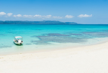 Fototapeta na wymiar Remote tropical paradise white sand beach full of healthy coral in clear blue turquoise lagoon, Okinawa