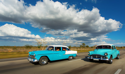 Old classic car on street of Cuba with white clouds and blue sky