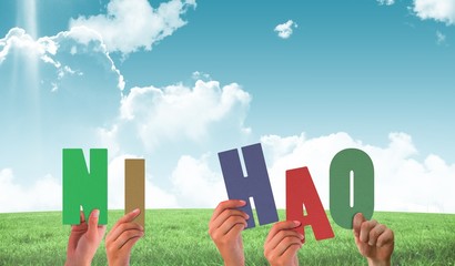 Obraz premium Composite image of hands holding up ni hao