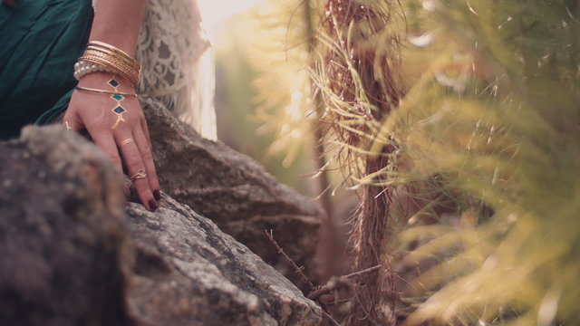 Woman's hand with boho style jewelry in nature