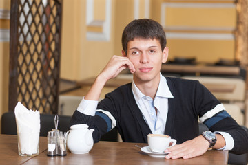 Young man across table with cup of coffee