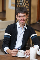 Young man across table with cup of coffee