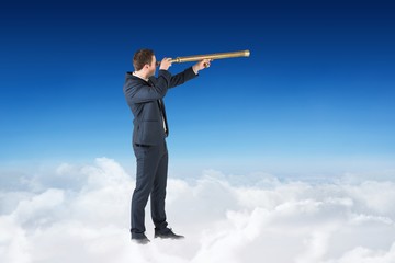 Obraz premium Composite image of businessman looking through telescope